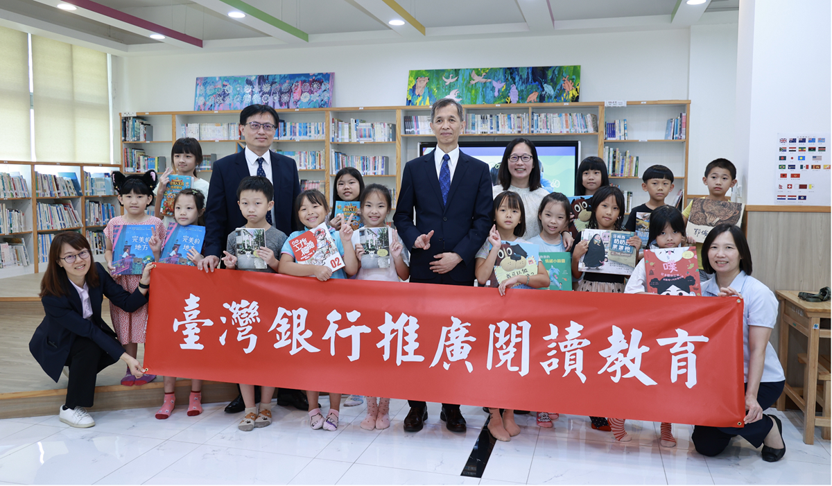 1140919-臺灣銀行副總經理李明華(前排中)親自前往新北市坪林國小贈送優質童書，與該校校長王佩君(後排右4)及學童開心合影。